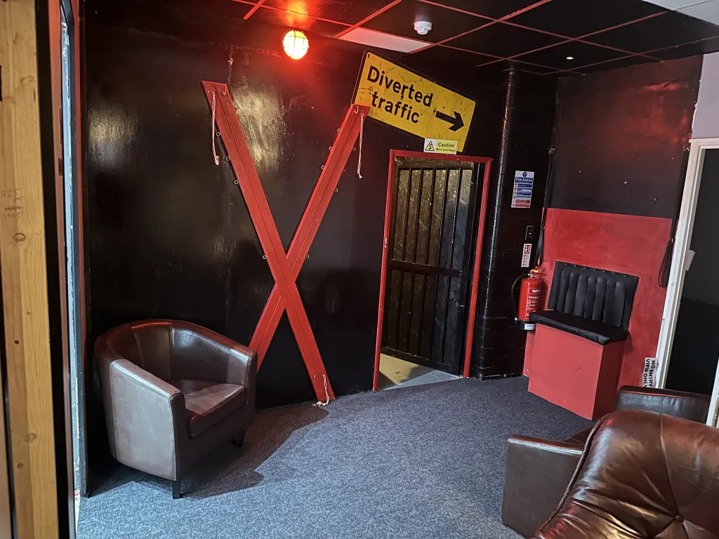Red and black lounge space inside The Naughty Pineapple